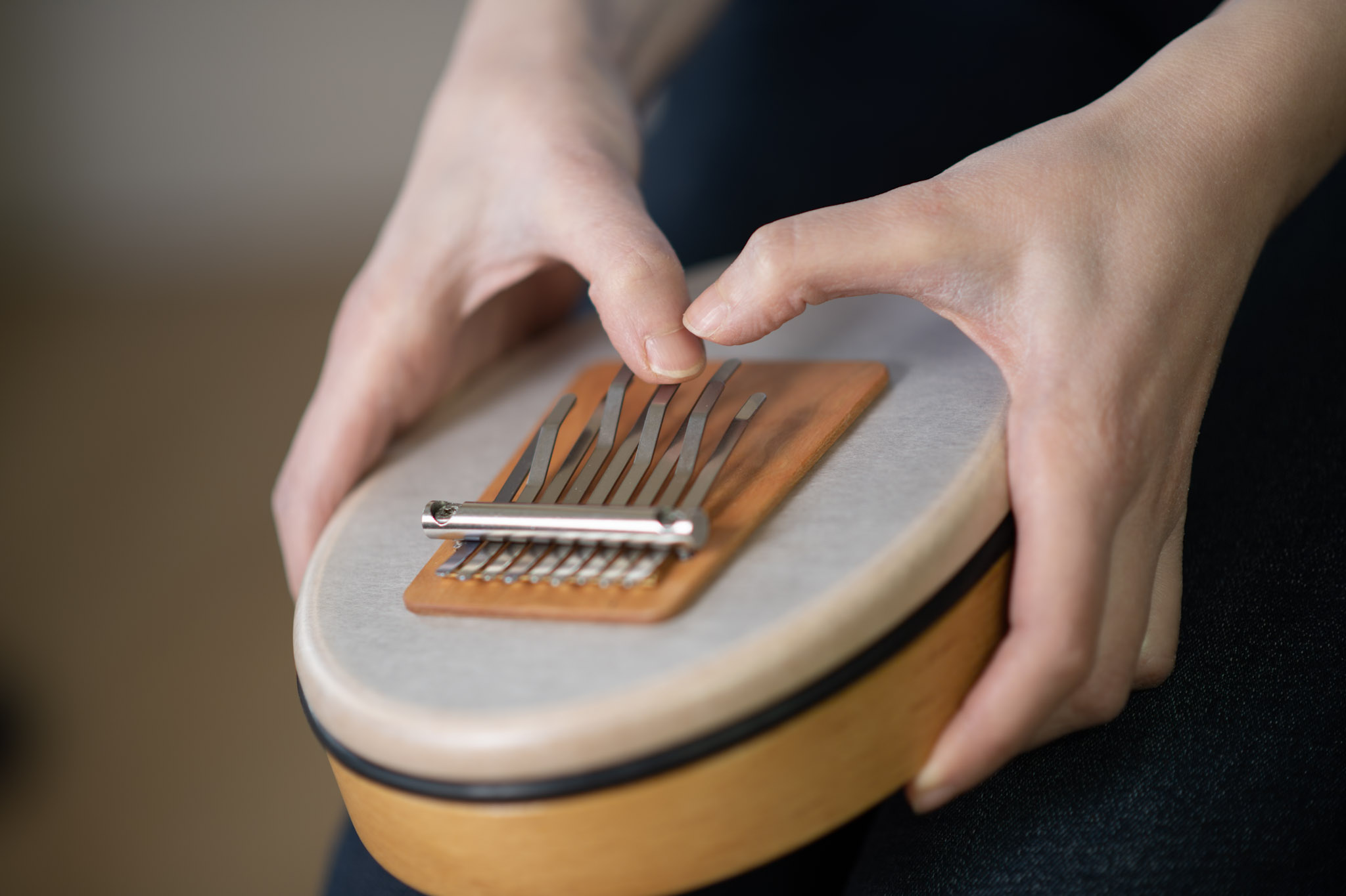 Nahaufnahme einer Kalimba auf einem Trommelfell, gespielt mit sanften Fingerbewegungen – ein beruhigendes Instrument in der Musiktherapie zur Förderung von Entspannung und innerer Harmonie.