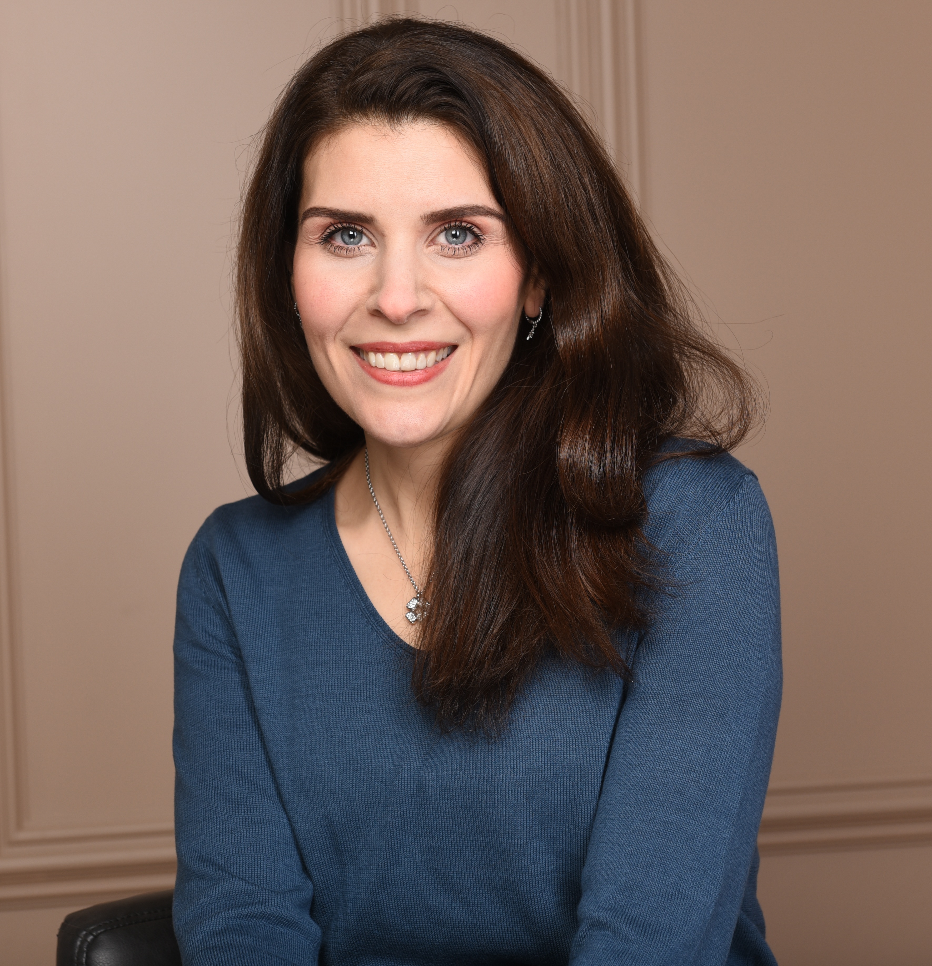 Portrait von Fatma Koslik, Musiktherapeutin in Bad Oeynhausen. Sie lächelt freundlich und trägt einen blauen Pullover – professionelle Musiktherapie für Entspannung und Wohlbefinden.